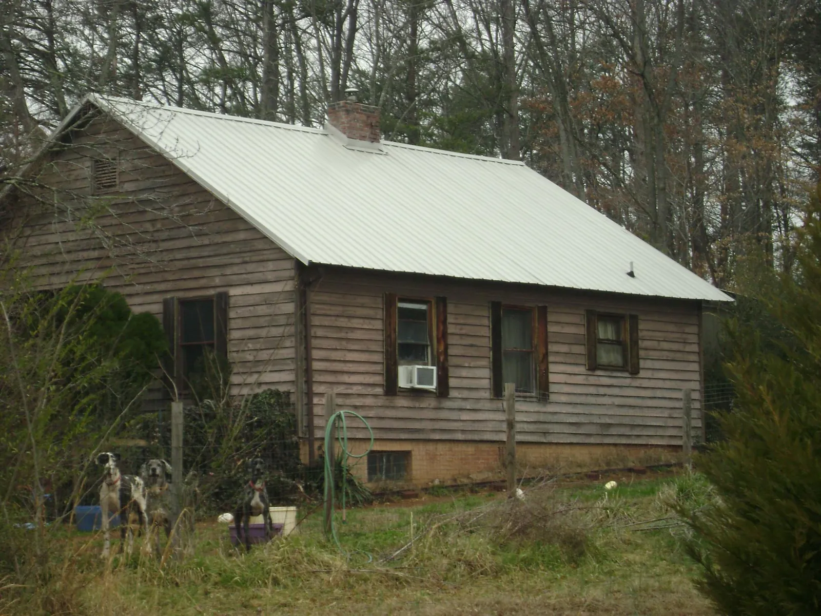 White metal roof on an old wood sided farmhouse, from a Metal Roof Installation job in Grant
